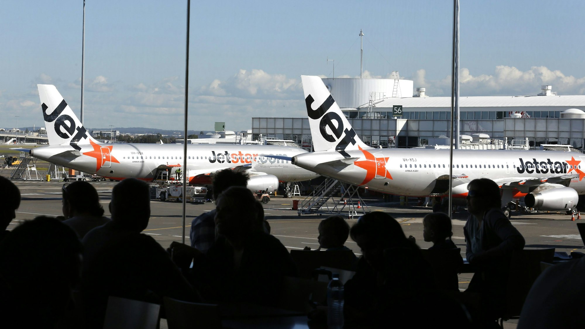 Flugzeuge der australischen Billigfluglinie Jetstar stehen auf einem Flughafen am Terminal.