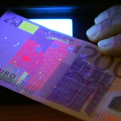 Zu sehen ist ein 200-Euro-Schein unter speziellem Licht.