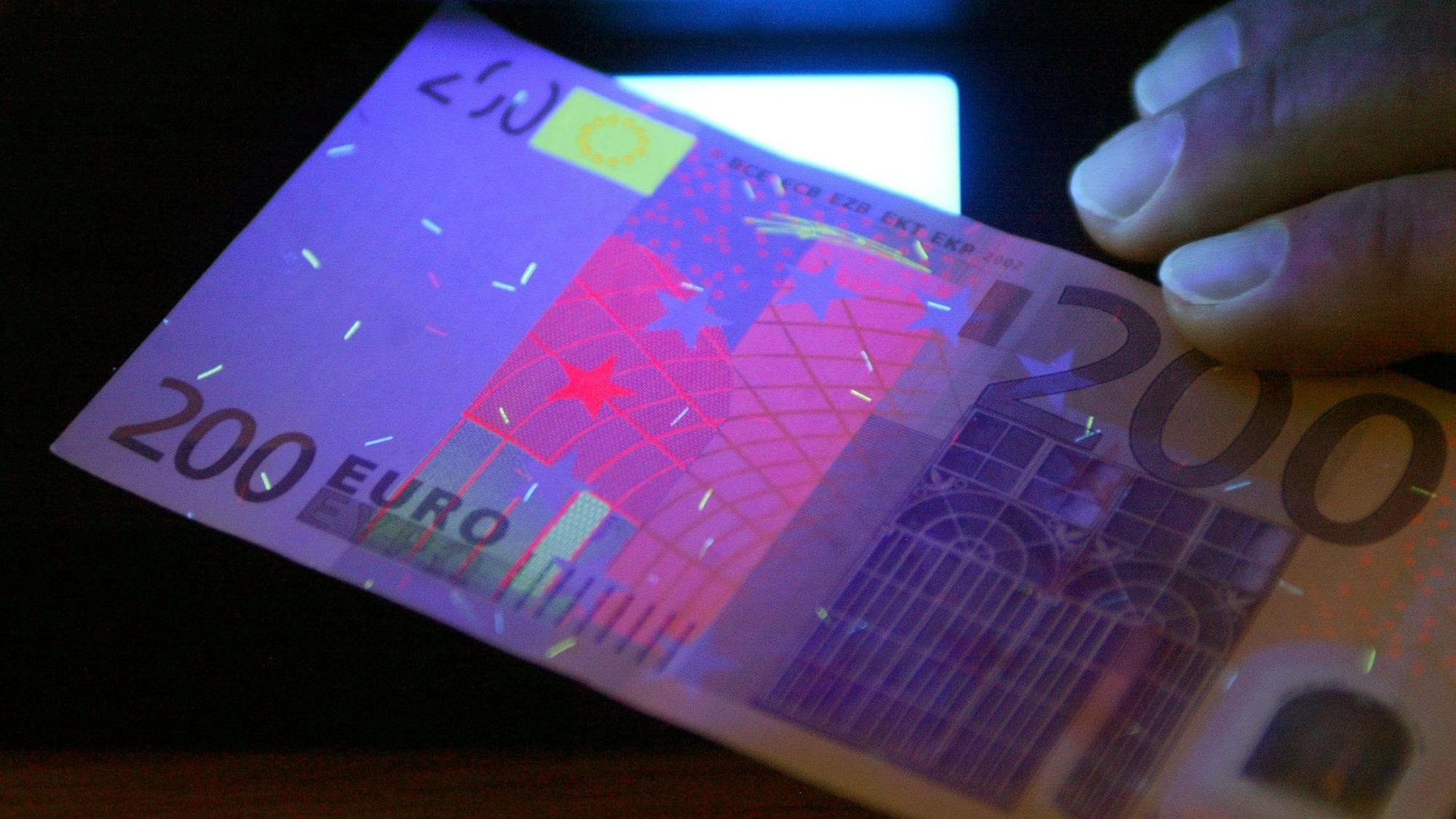 Zu sehen ist ein 200-Euro-Schein unter speziellem Licht.