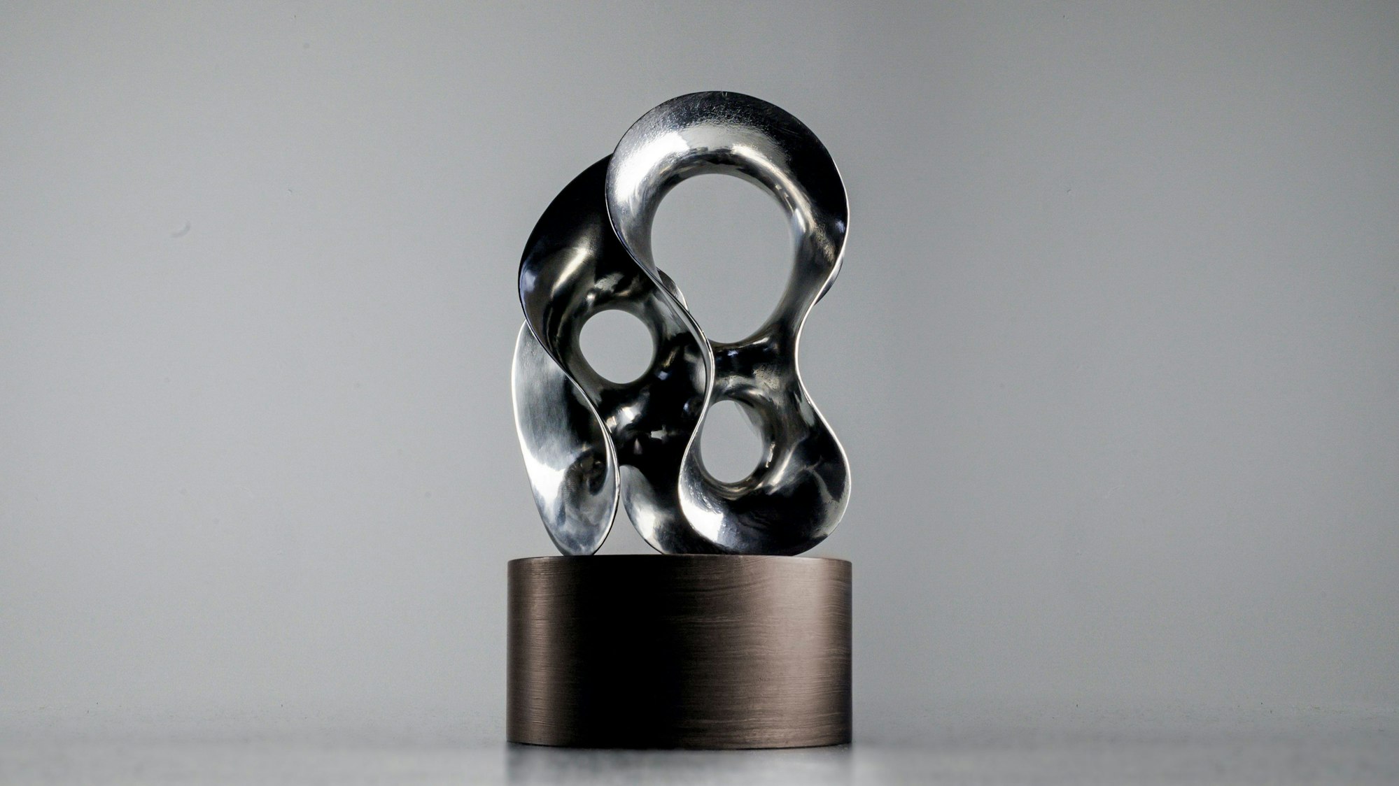 Eine Metallskulptur steht auf einem Podest.