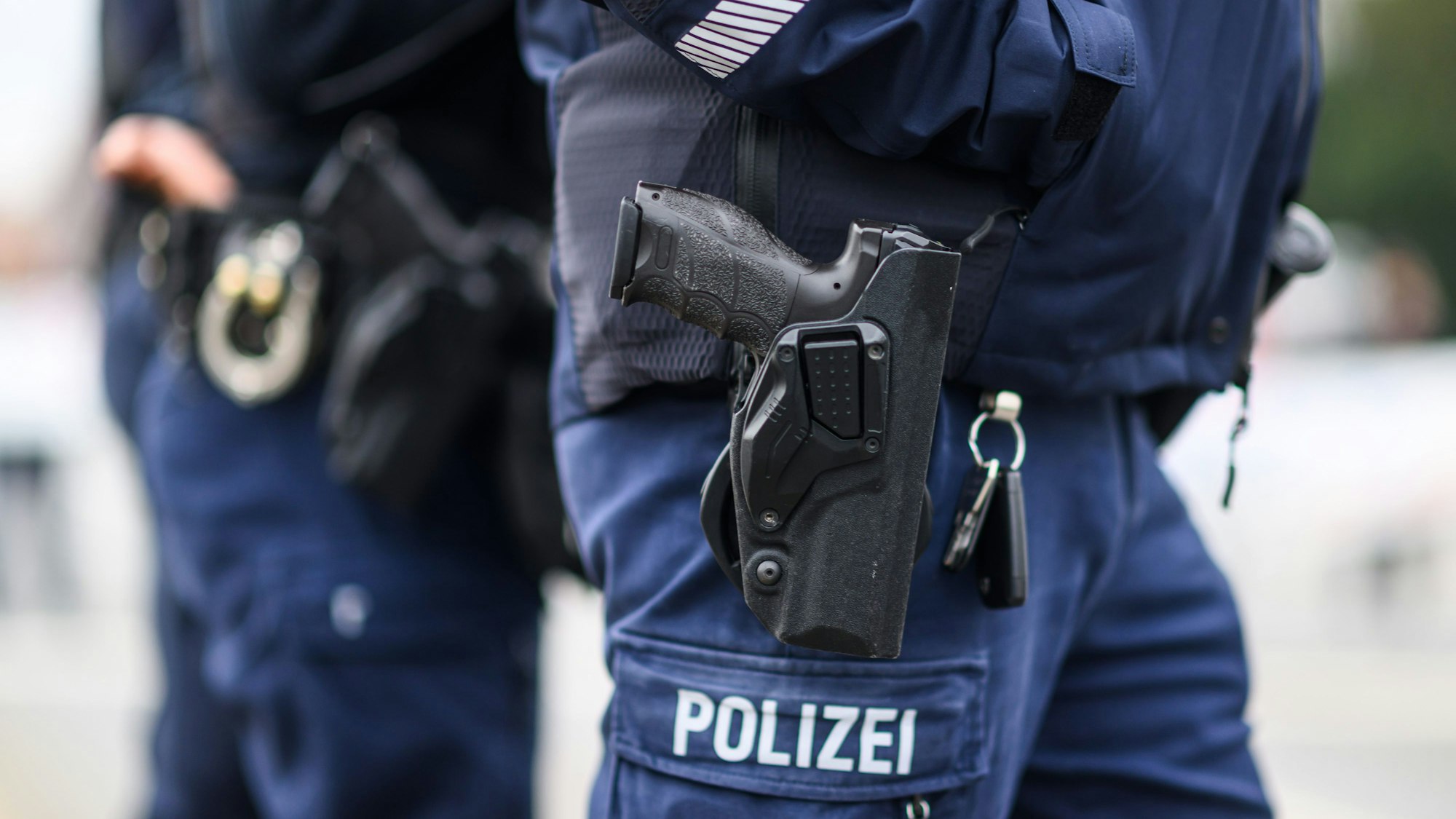 Ein Polizist mit Dienstwaffe ist zu sehen.