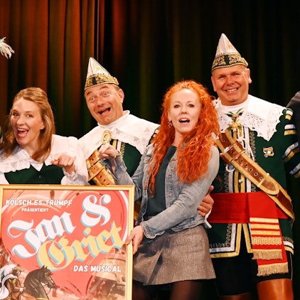 Menschen halten Musical-Plakat hoch.