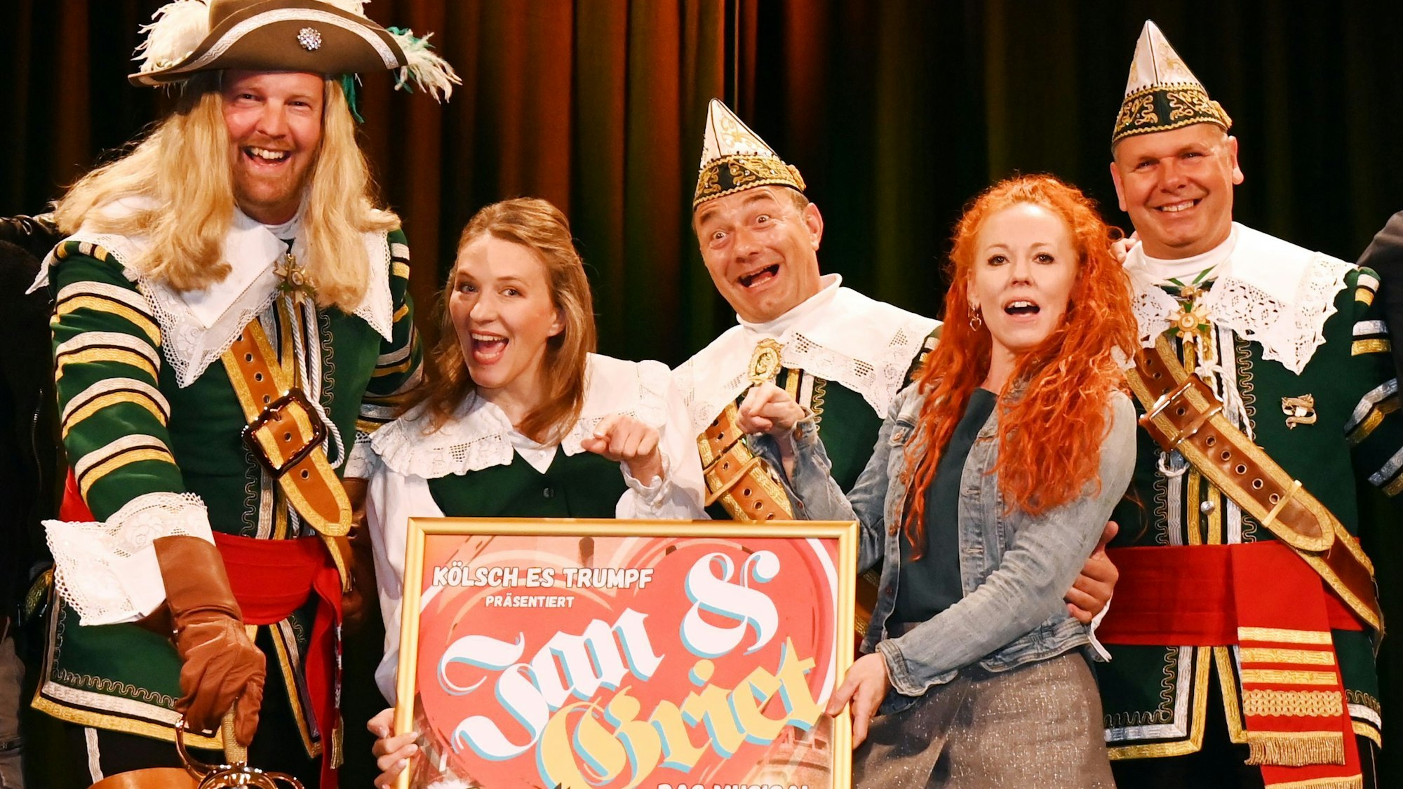 Menschen halten Musical-Plakat hoch.