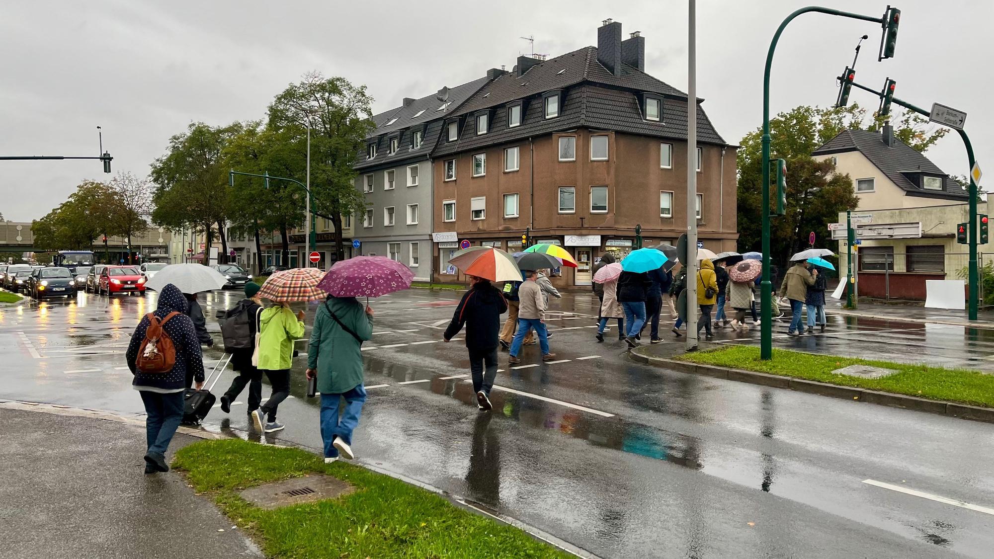 Fußgänger hetzen über die Gustav-Heinemann-Straße.