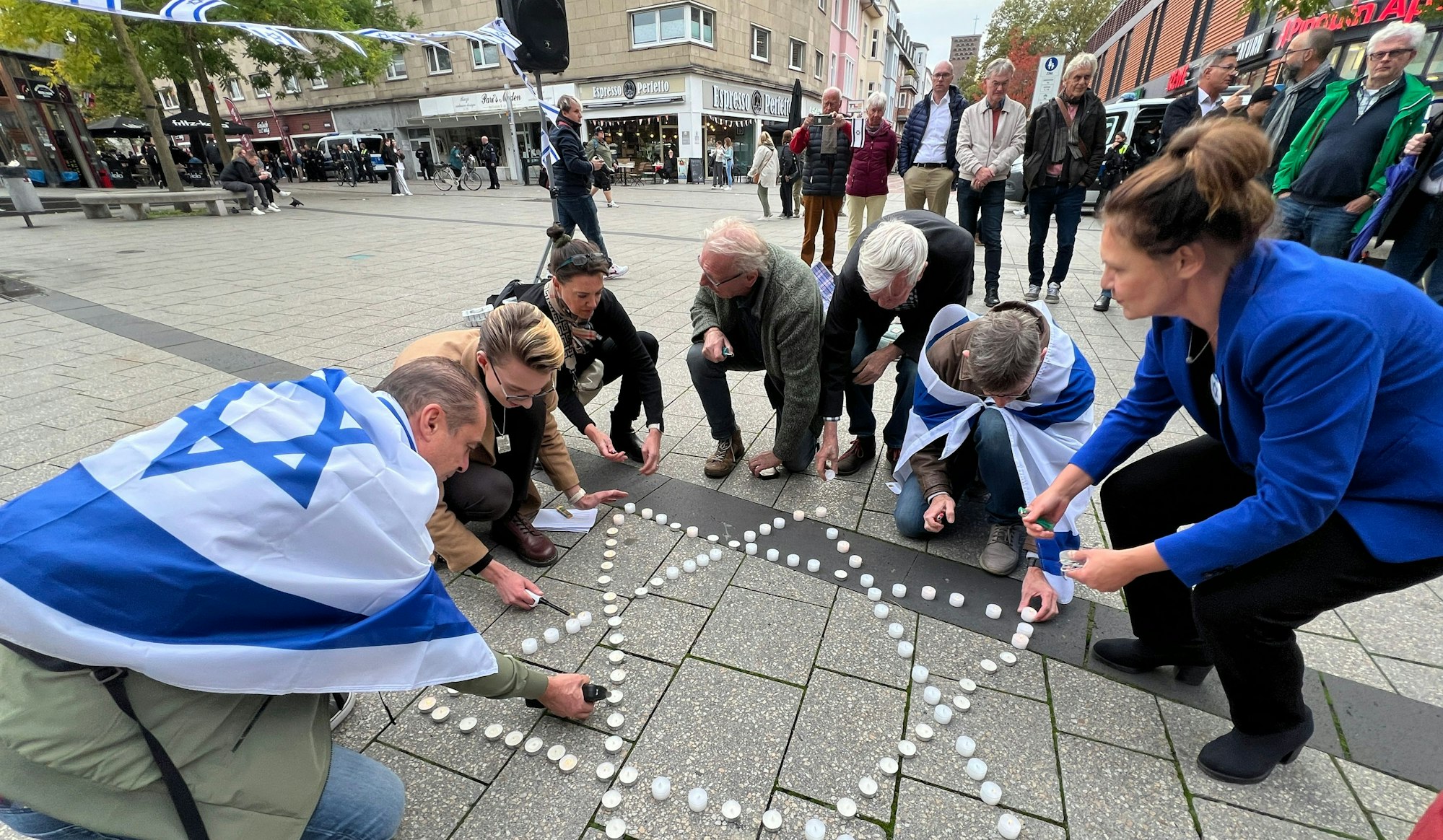 In Gedenken für die Opfer des Hamas-Pogroms vor einem Jahr legten Teilnehmer der Mahnwache auf dem Rathausvorplatz einen Davidstern aus Krezen.