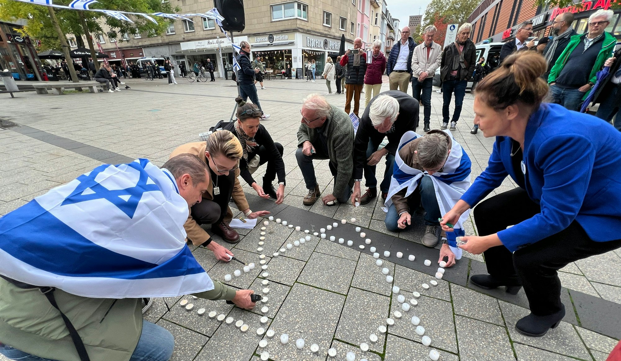 In Gedenken für die Opfer des Hamas-Pogroms vor einem Jahr legten Teilnehmer der Mahnwache auf dem Rathausvorplatz einen Davidstern aus Krezen.