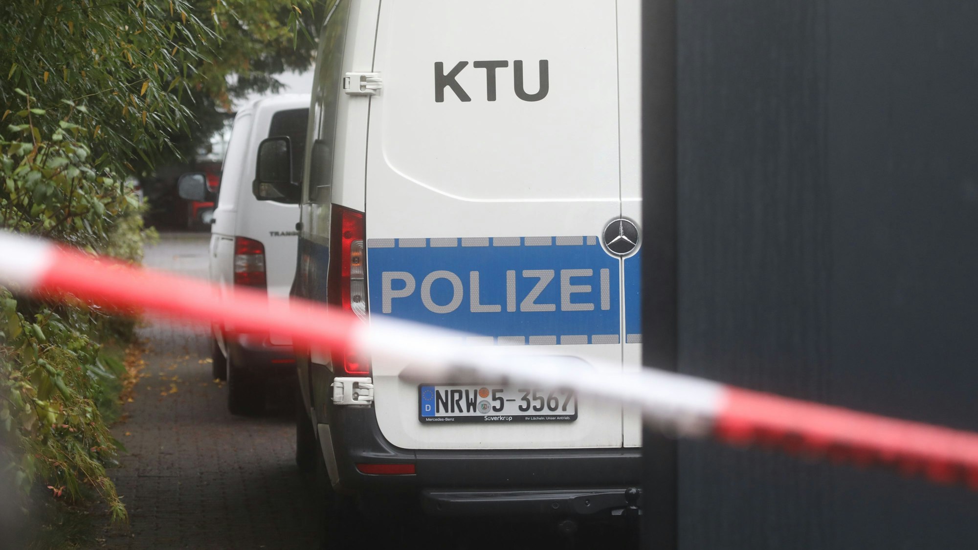 Ein Einsatzfahrzeug der KTU (Kriminaltechnische Untersuchung) steht vor einem Wohnhaus im Stadtteil Hahnwald, das nach einem Leichenfund weiträumig abgesperrt wurde.
