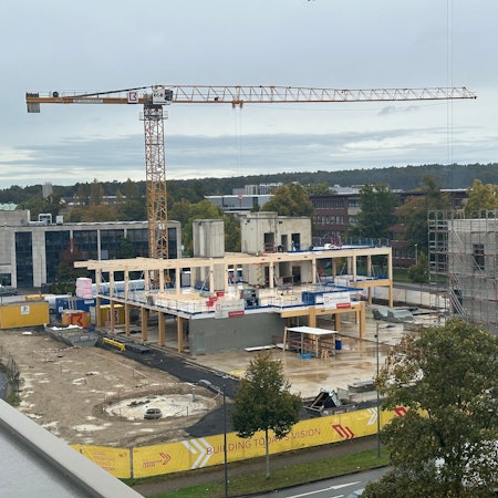 DHL baut ein neues Innovation-Center in Troisdorf, Richtfest war am 9. Oktober 2024. Blick auf den Rohbau mit einem Kran und Beton- sowie Holzfertigteilen.