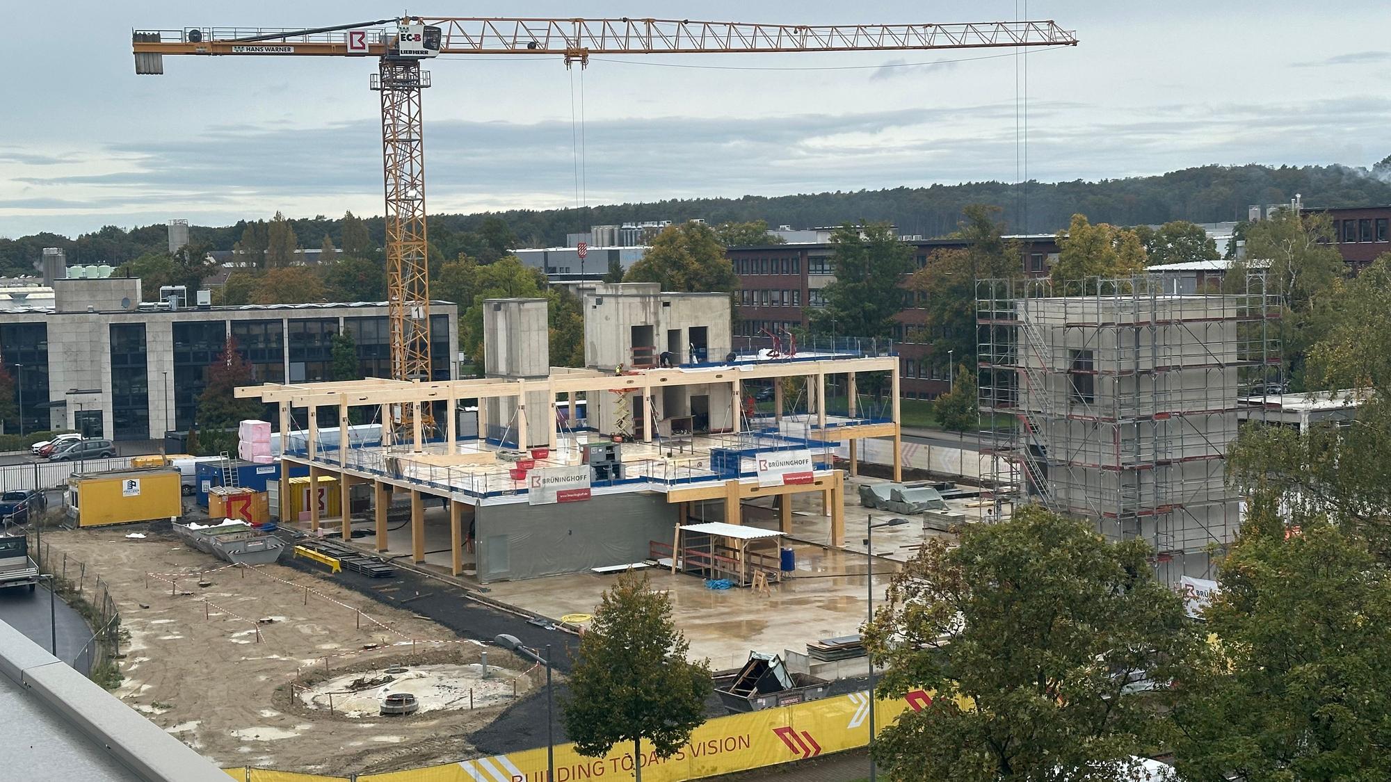 DHL baut ein neues Innovation-Center in Troisdorf, Richtfest war am 9. Oktober 2024. Blick auf den Rohbau mit einem Kran und Beton- sowie Holzfertigteilen.