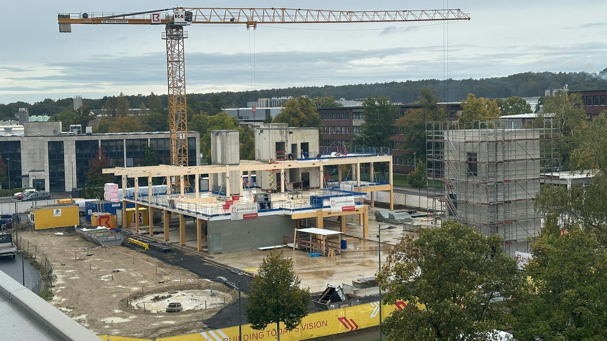DHL baut ein neues Innovation-Center in Troisdorf, Richtfest war am 9. Oktober 2024. Blick auf den Rohbau mit einem Kran und Beton- sowie Holzfertigteilen.