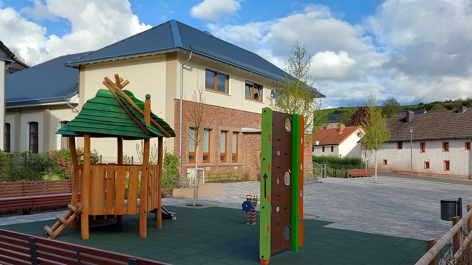 Spielgeräte und Sitzbänke stehen auf dem Dorfplatz von Dahlem.
