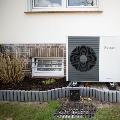 Eine Wärmepumpe steht vor einem Haus.