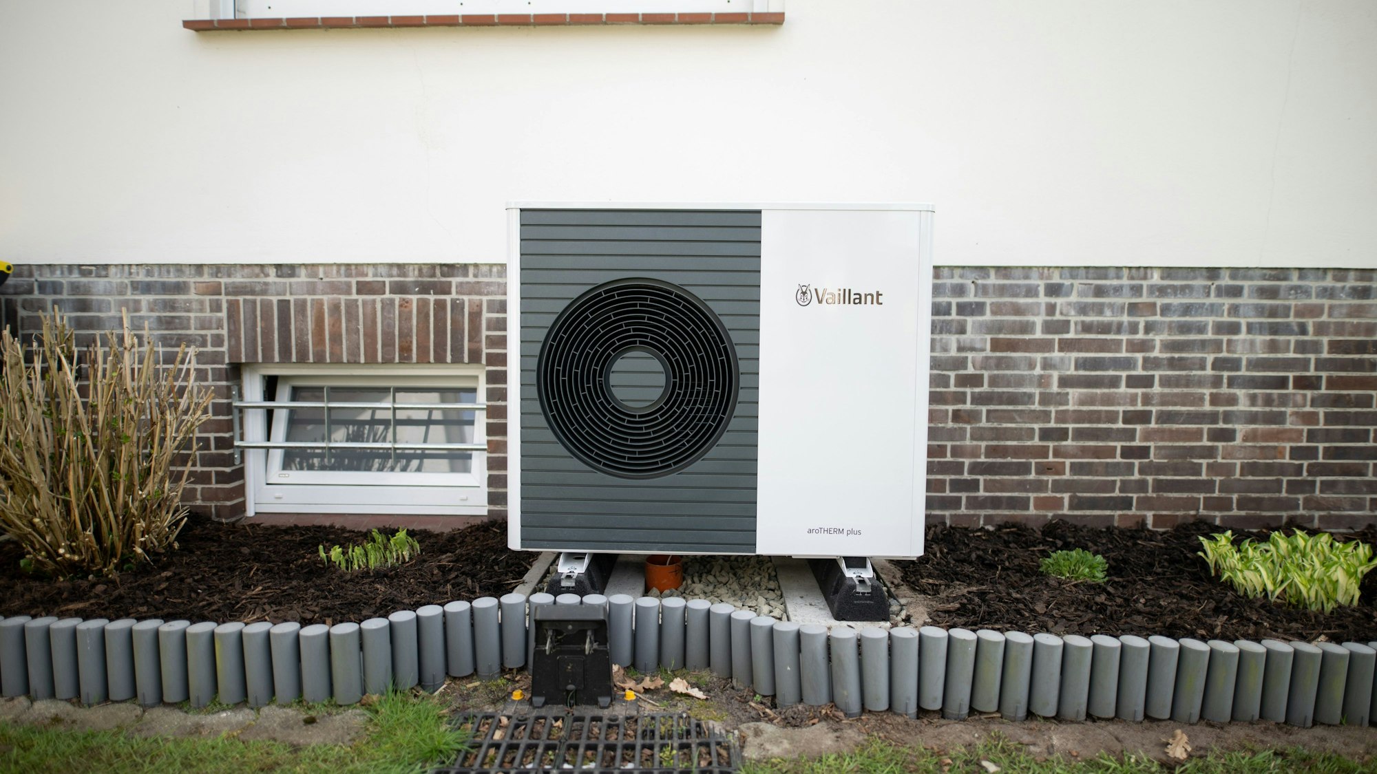Eine Wärmepumpe steht vor einem Haus.