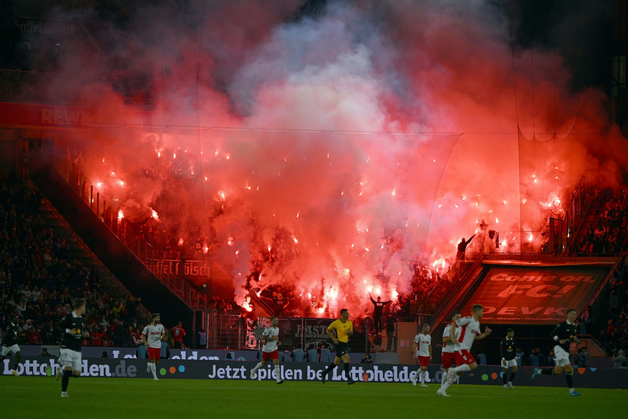 Dutzende Bengalen brennen im Gästeblock, in dem sich offenbar Tausende FC-Fans befinden.