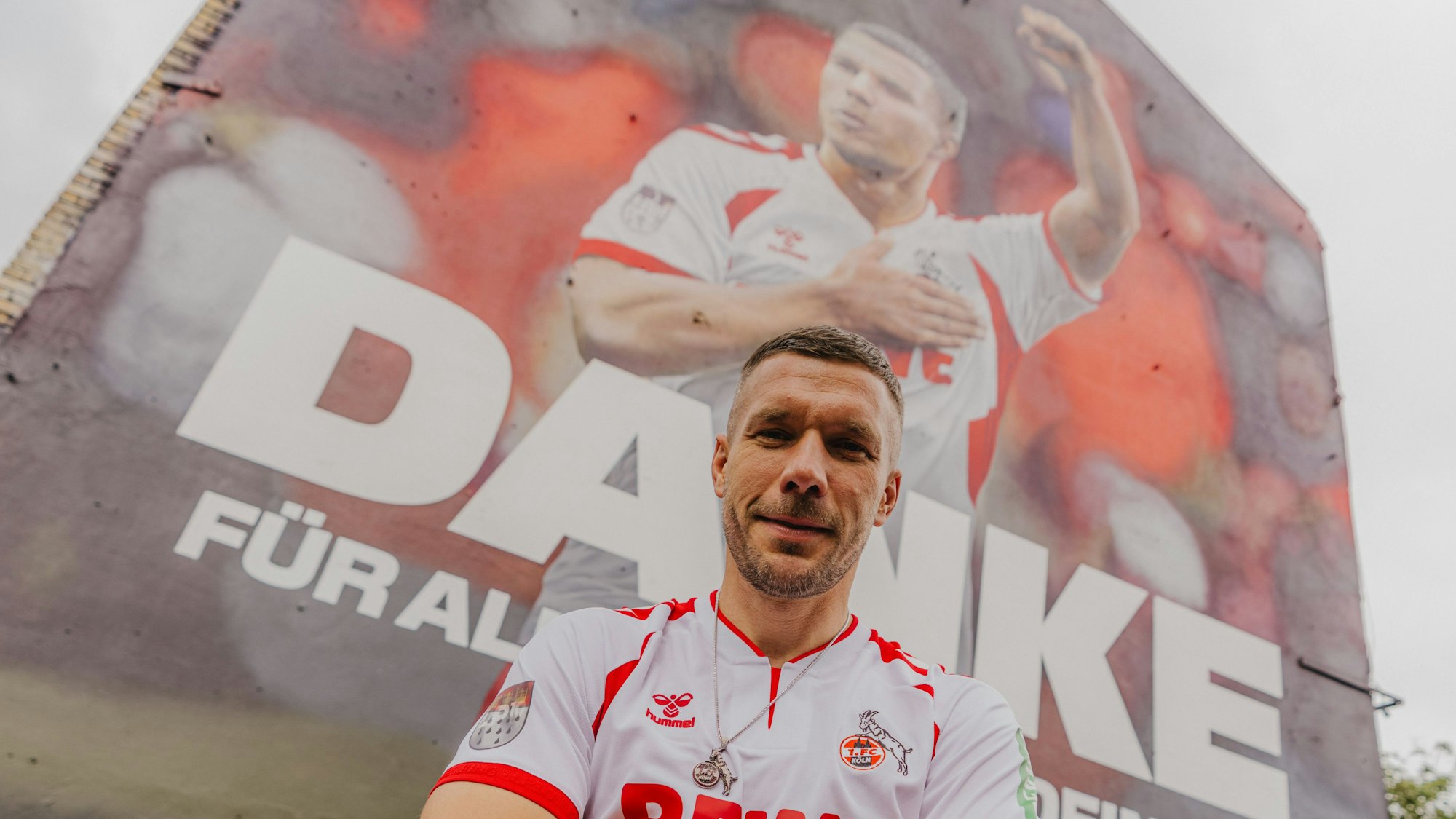 Lukas Podolski vor dem Wandgemälde in Ehrenfeld.