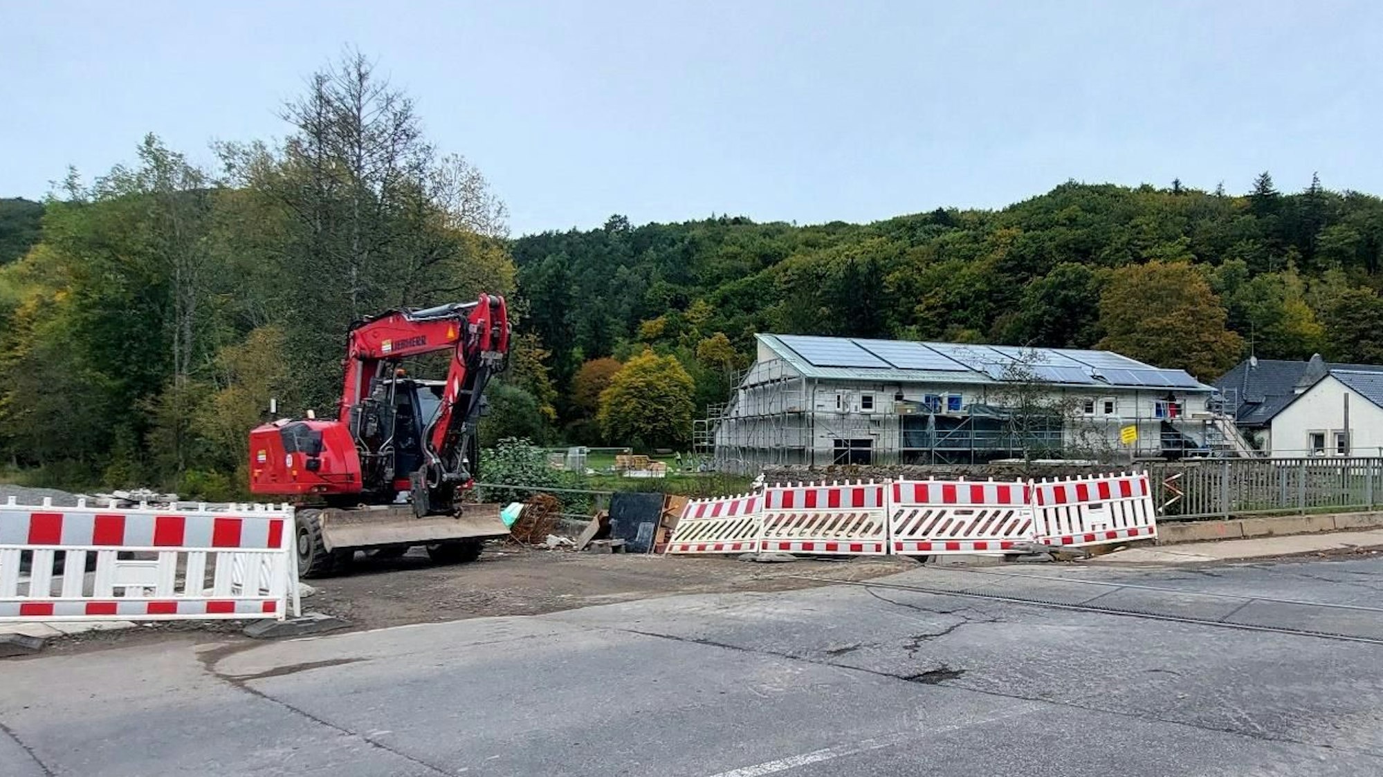 Ein Bagger steht am Bahnübergang in Kall-Urft.