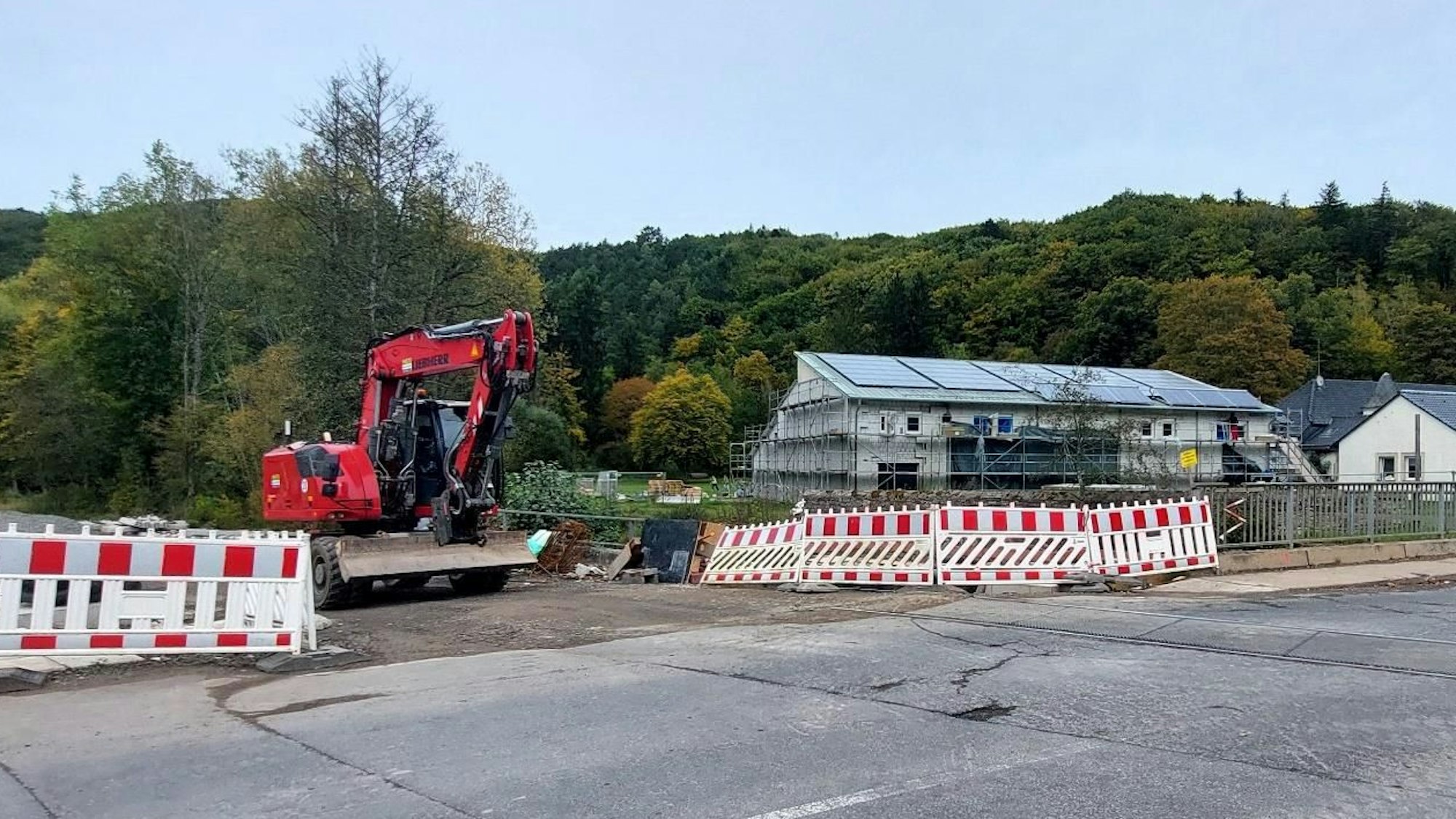 Ein Bagger steht am Bahnübergang in Kall-Urft.