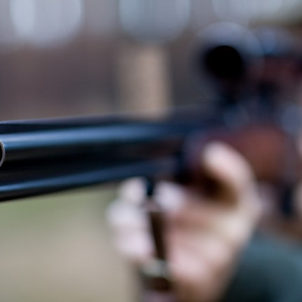 Ein Mann zielt mit seinem Jagdgewehr.
