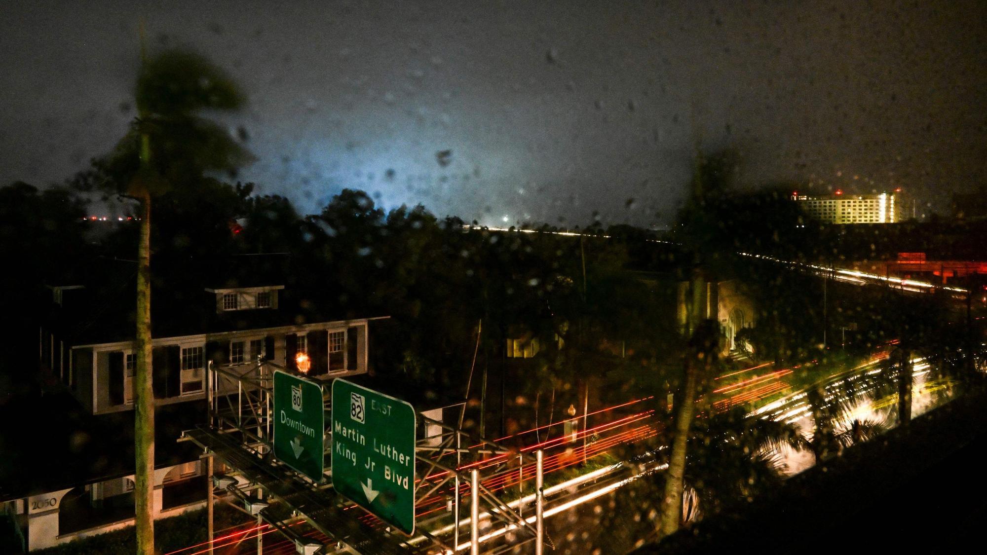 Ein Stromtransformator explodiert und erzeugt ein Licht im Hintergrund, als der Hurrikan Milton am 9. Oktober 2024 in Fort Myers, Florida, an Land geht.