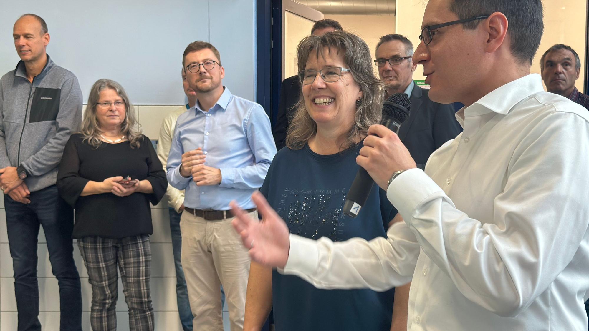 Bürgermeister Max Leitterstorf hält ein Mikrofon in der Hand und lobt in seiner Rede die Arbeit der städtische Projektleiterin Wenke Schallenberg-Hüls, die neben ihm steht.