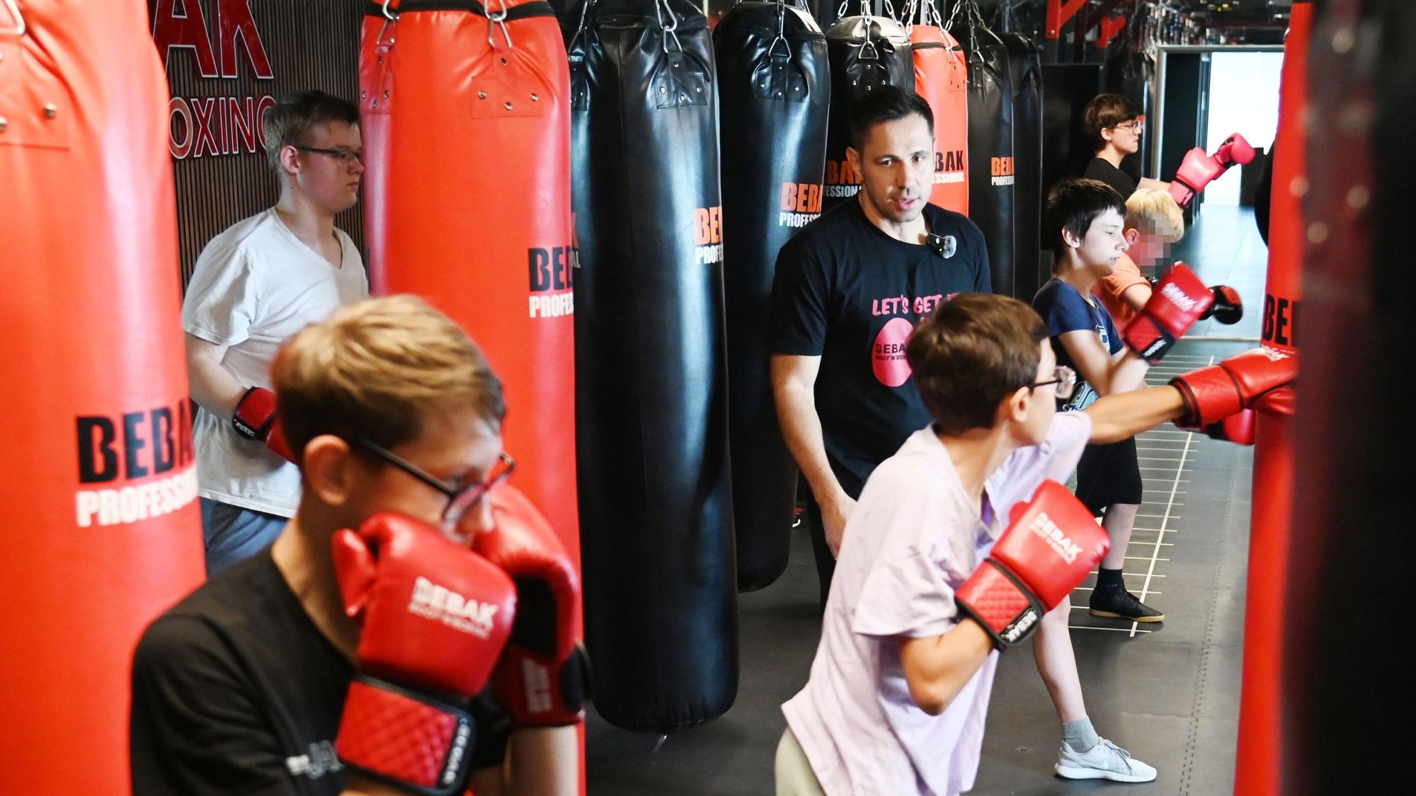 Jugendliche trainieren an Boxsäcken in einem Fitnessstudio
