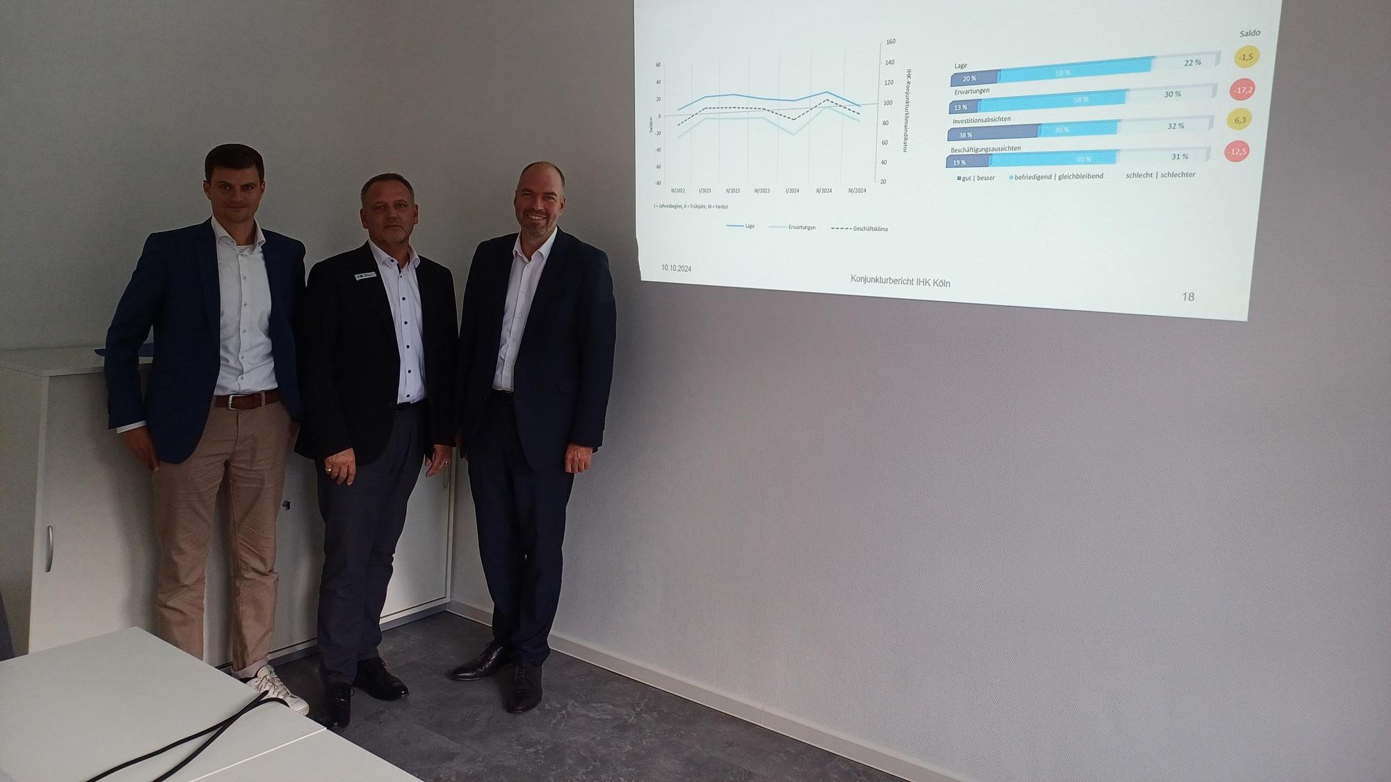 Matthias Franken (v.l.), Jörg Hausmann und Hendrik Pilatzki von der IHK zeigen die Statistik für Leverkusen.