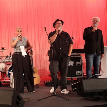 Musikerinnen und Musiker des Projekts „Kölsche Heimat“ auf einer Bühne im Foyer der Kreissparkasse Köln am Neumarkt