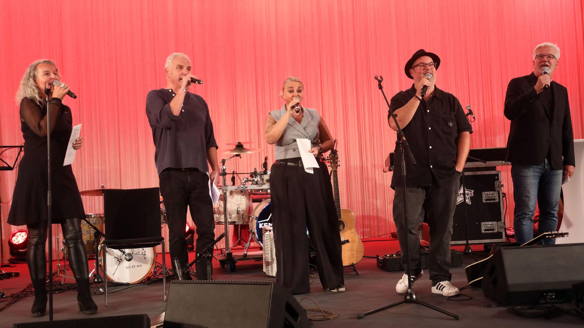 Musikerinnen und Musiker des Projekts „Kölsche Heimat“ auf einer Bühne im Foyer der Kreissparkasse Köln am Neumarkt