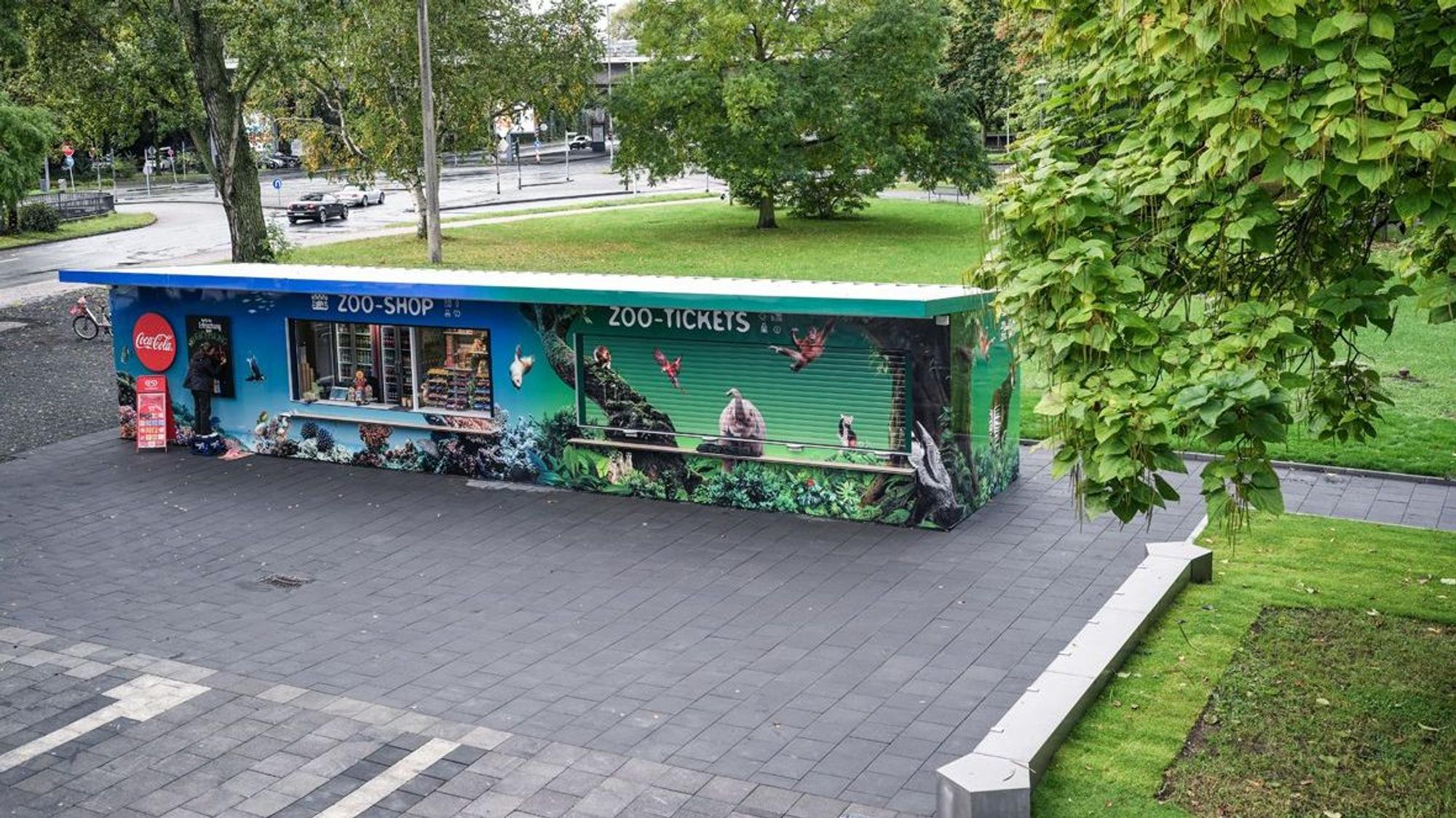 Die neue Kasse des Kölner Zoos vor dem Haupteingang, daneben neue Grünflächen und Sitzgelegenheiten.