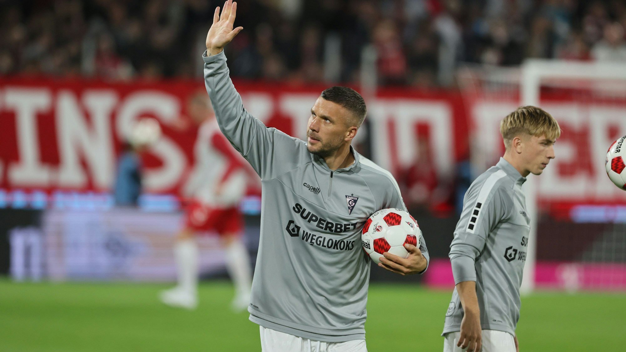 Grüße ins Publikum: Lukas Podolksi bereitet sich auf sein Abschiedsspiel vor.