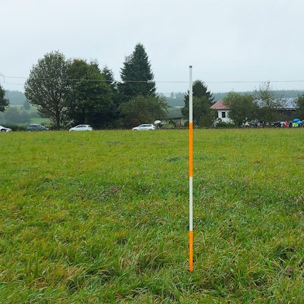 Das Bild zeigt eine Wiese bei Schmidtheim, im Hintergrund ist ein landwirtschaftliches Betriebsgebäude zu erkennen.