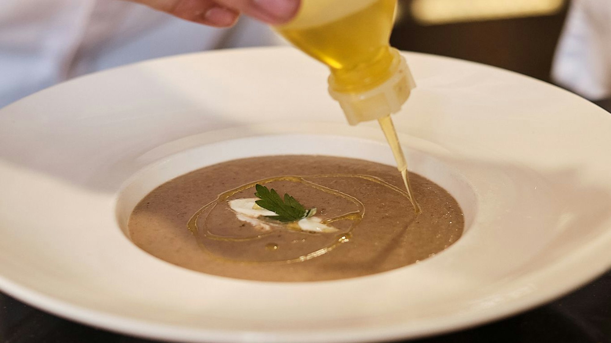 Ein TL Schmand in die Mitte geben, etwas Olivenöl darüber träufeln.