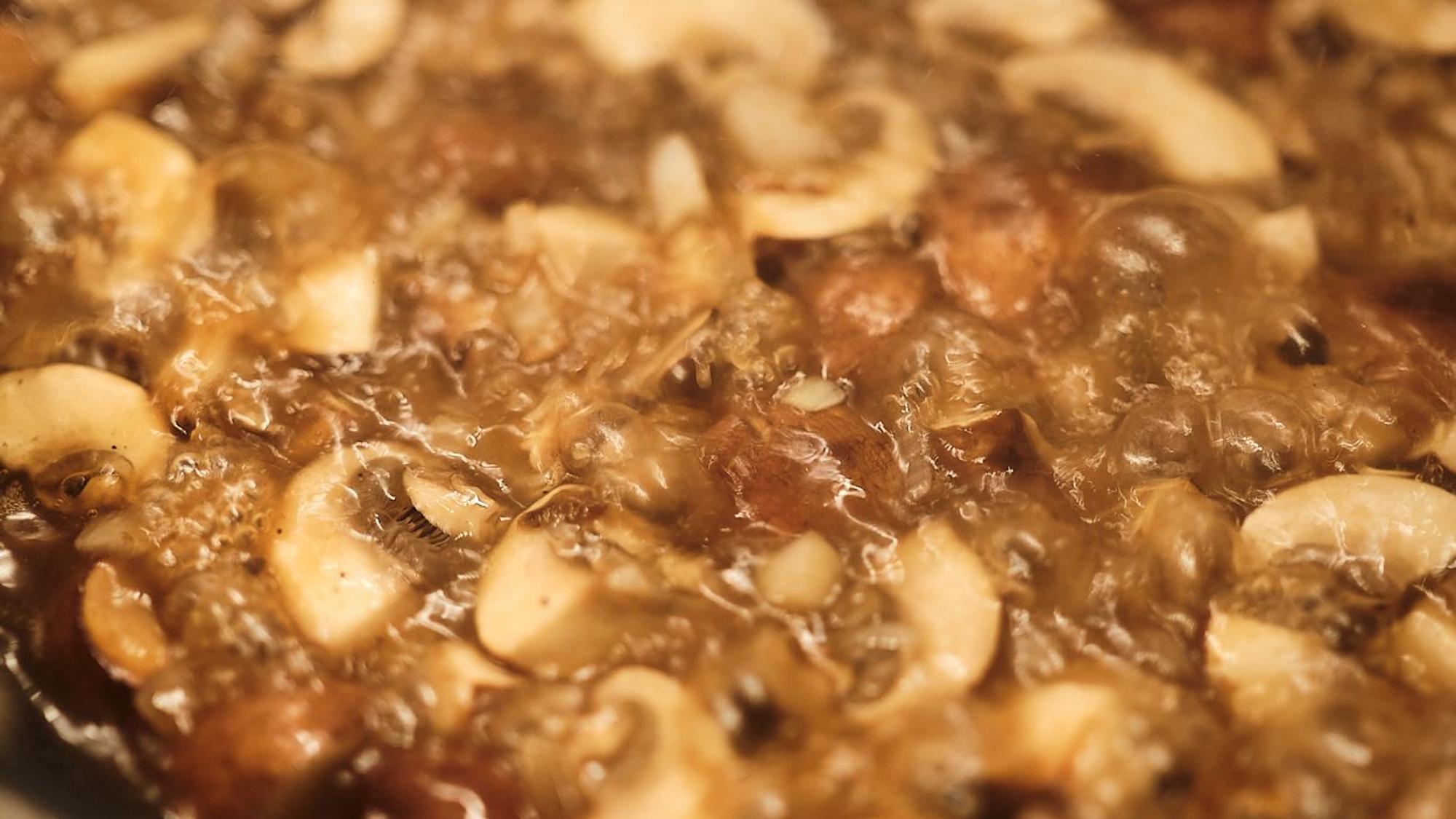 Brutzelnde Pilze in der Pfanne