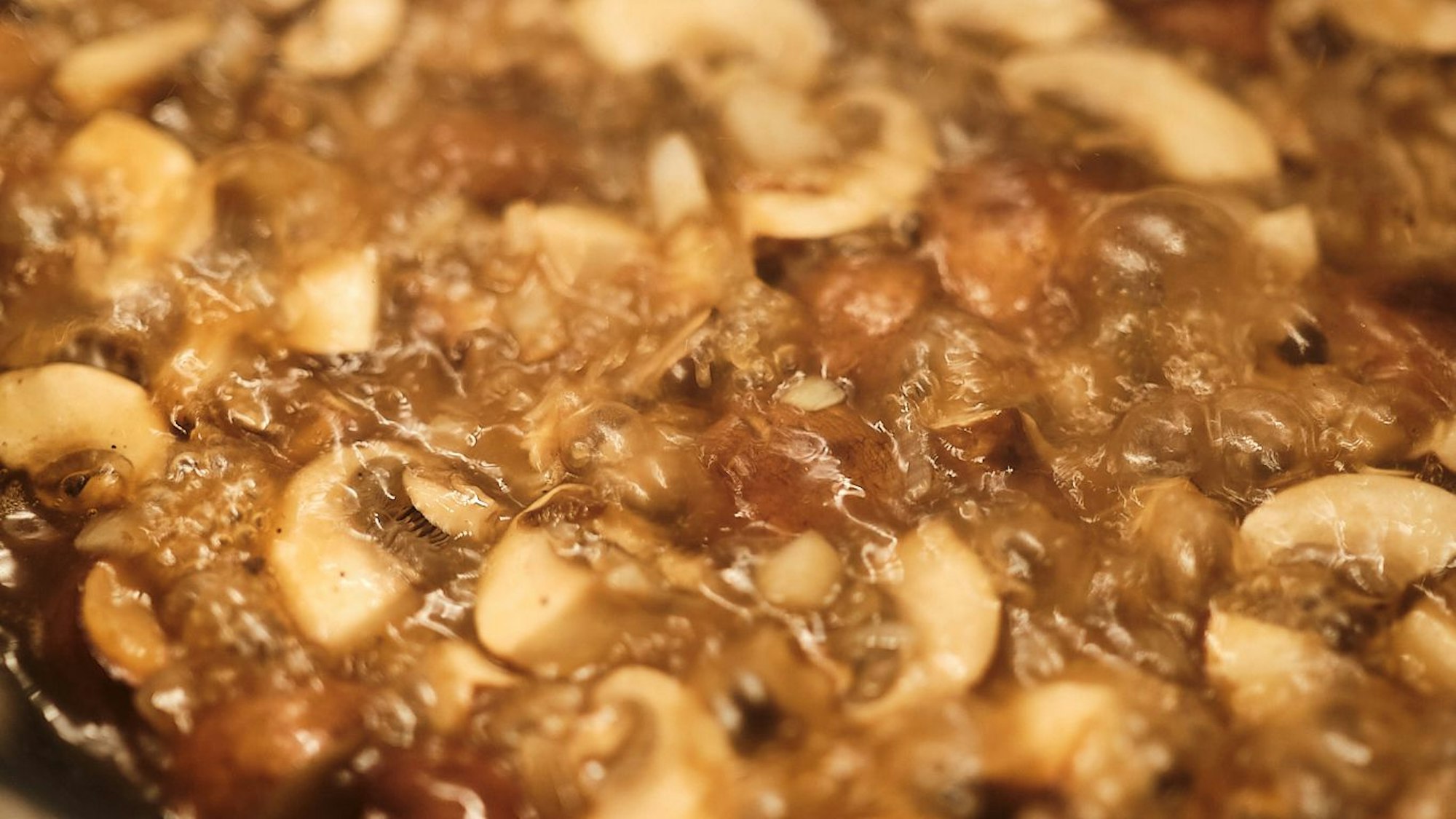 Brutzelnde Pilze in der Pfanne