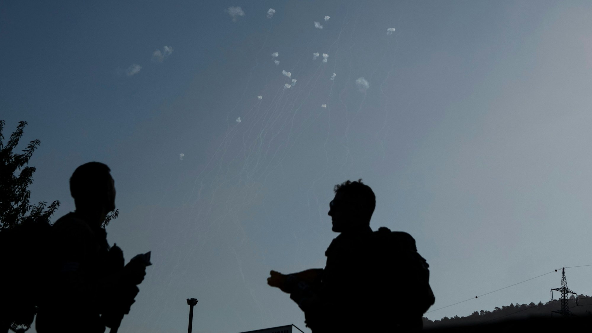 Angehörige der israelischen Streitkräfte beobachten im Norden Israels, wie das Luftabwehrsystem Iron Dome Raketen abfängt, die aus dem Libanon abgeschossen wurden.