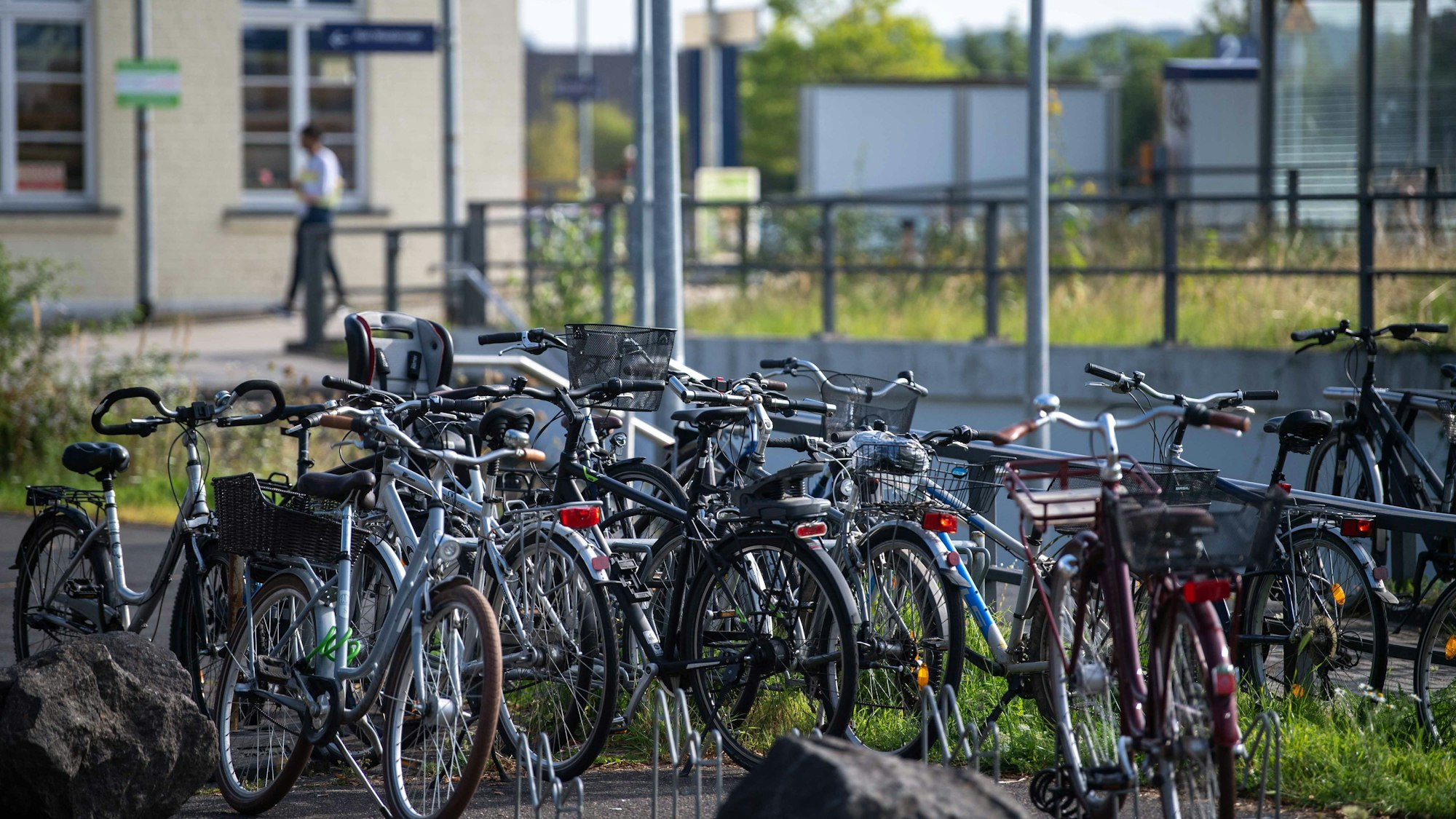 Fahrräder stehen dicht nebeneinander in der Nähe eines Bahnsteigs.