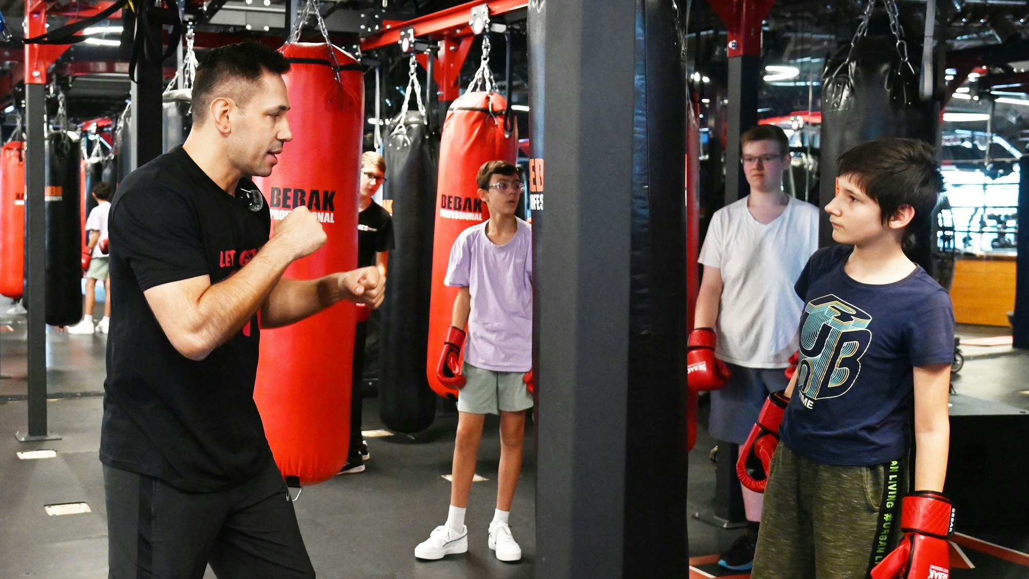 Felix Sturm zeigt Jugendlichen Box-Techniken an einem Boxsack