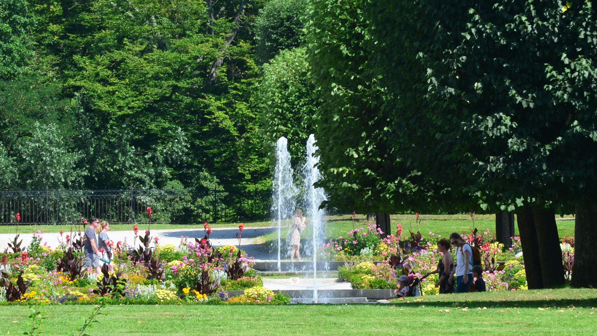Menschen gehen durch den Schlosspark.