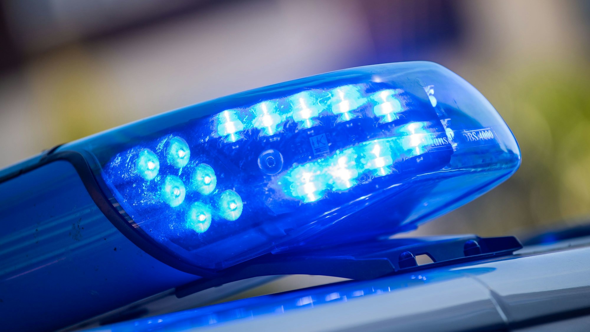Ein Blaulicht ist auf dem Dach eines Polizeifahrzeugs zu sehen.