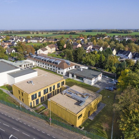 Ein Luftbild des Instituts, das aus mehreren Komplexen besteht; im Hintergrund Wohnhäuser.