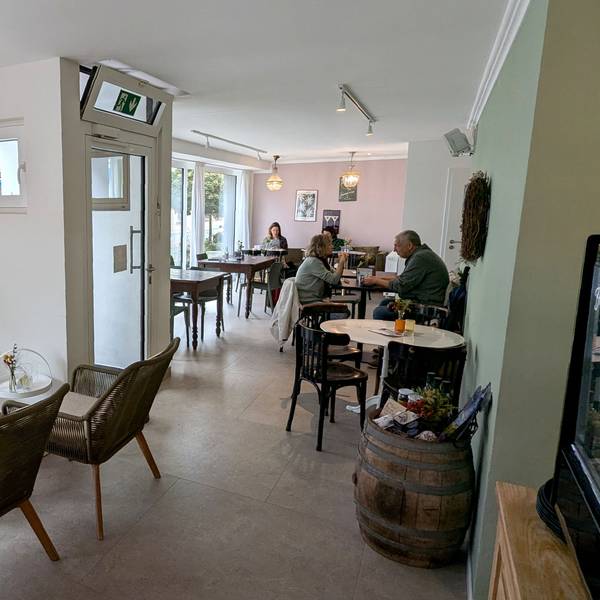 Blick in den Gastraum der Café-Bar Lou in Gemünd, wo ein paar Gäste an Tischen sitzen.