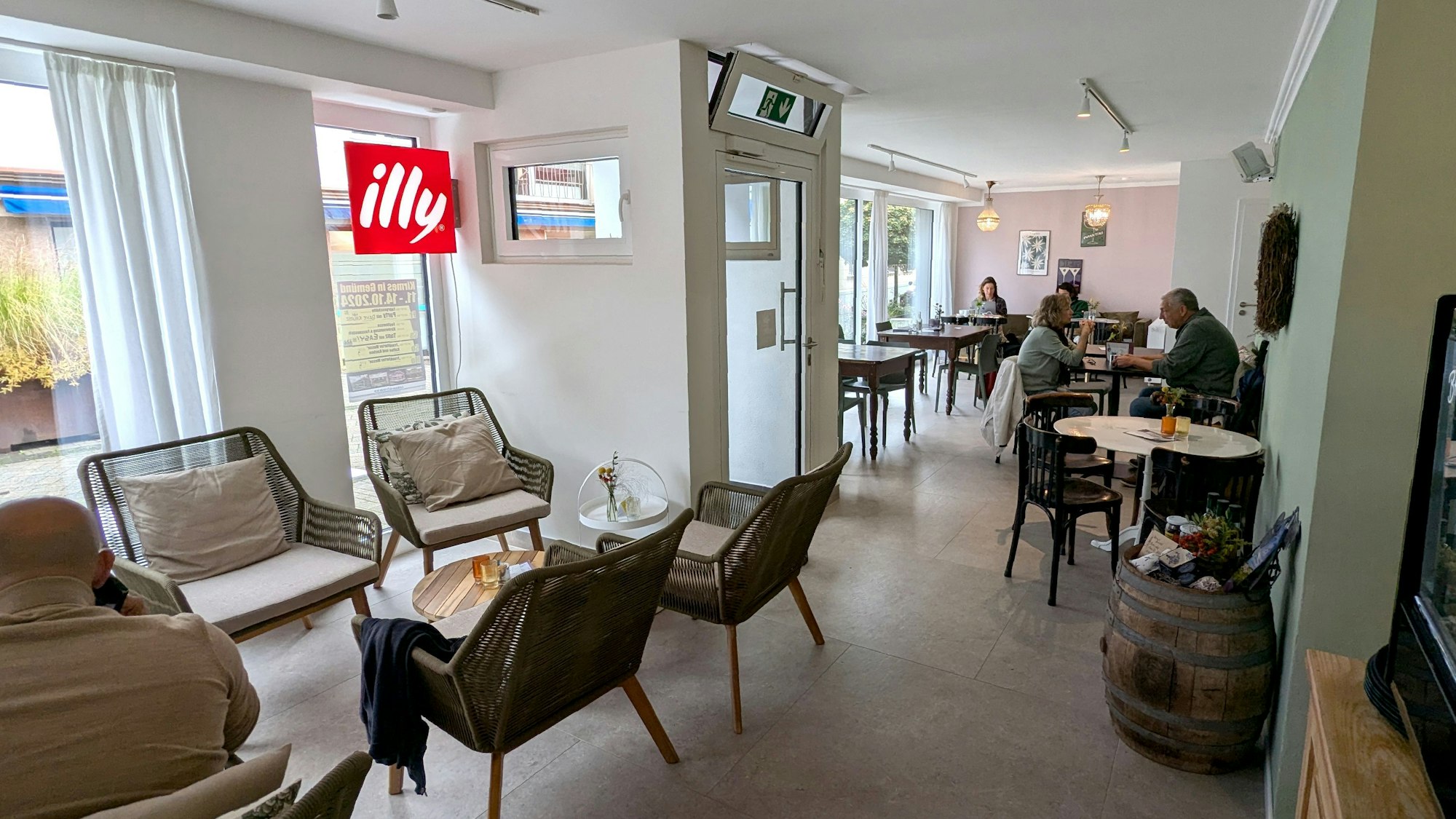 Blick in den Gastraum der Café-Bar Lou in Gemünd, wo ein paar Gäste an Tischen sitzen.