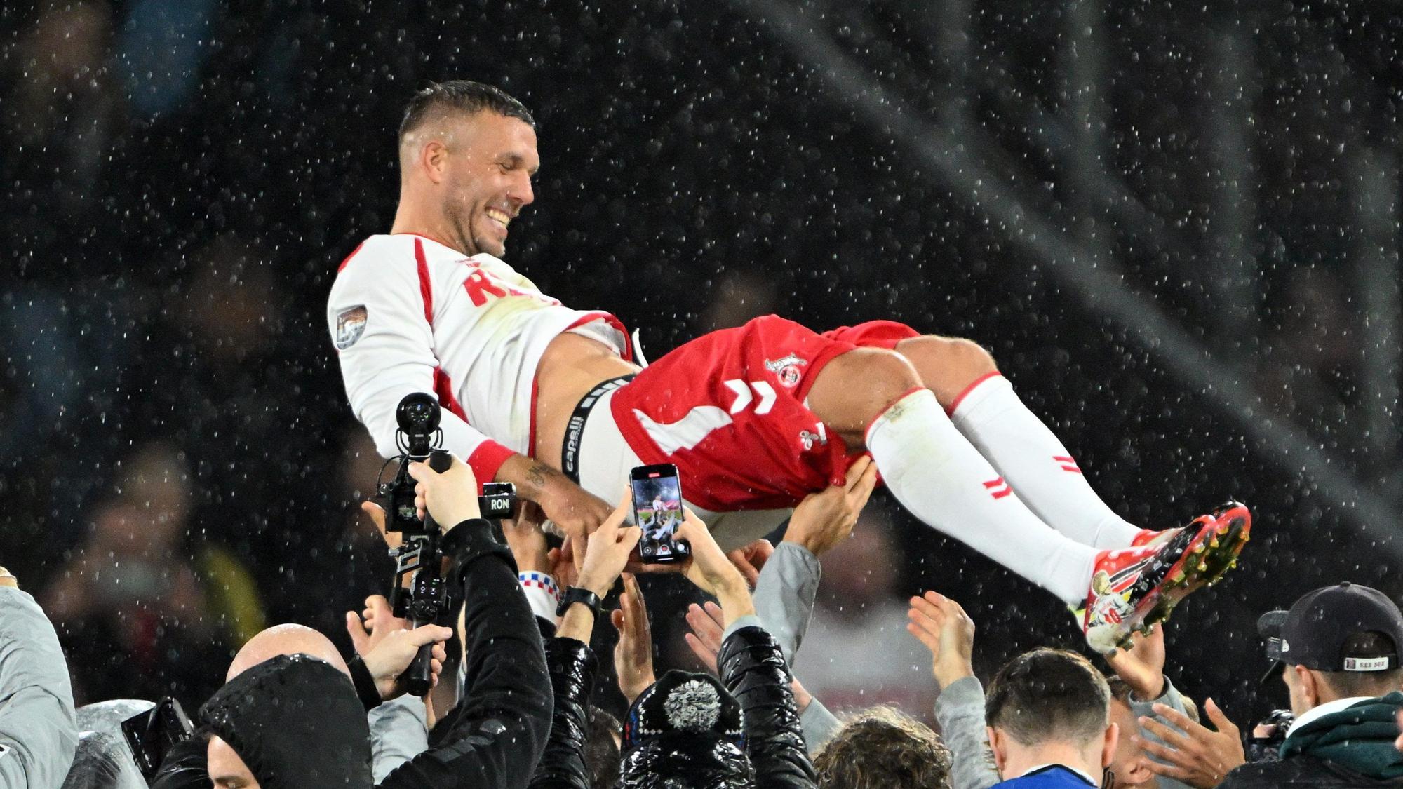 10.10.2024, Nordrhein-Westfalen, Köln: Fußball: Abschiedsspiel von Lukas Podolski beim 1. FC Köln, Mitspieler werfen Lukas Podolski in die Höhe. (zu dpa: «Rückkehr erwünscht: Köln umwirbt Kultfigur Podolski») Foto: Federico Gambarini/dpa +++ dpa-Bildfunk +++