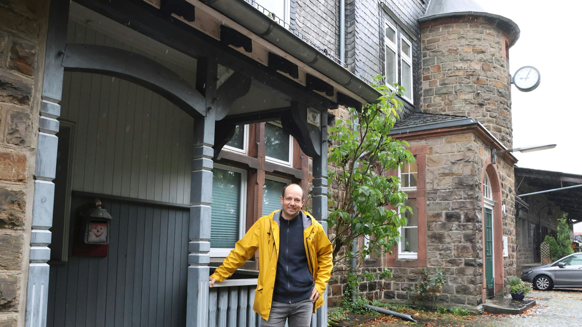 Ein Mann steht vor der Vorderfront des Bahnhofs.