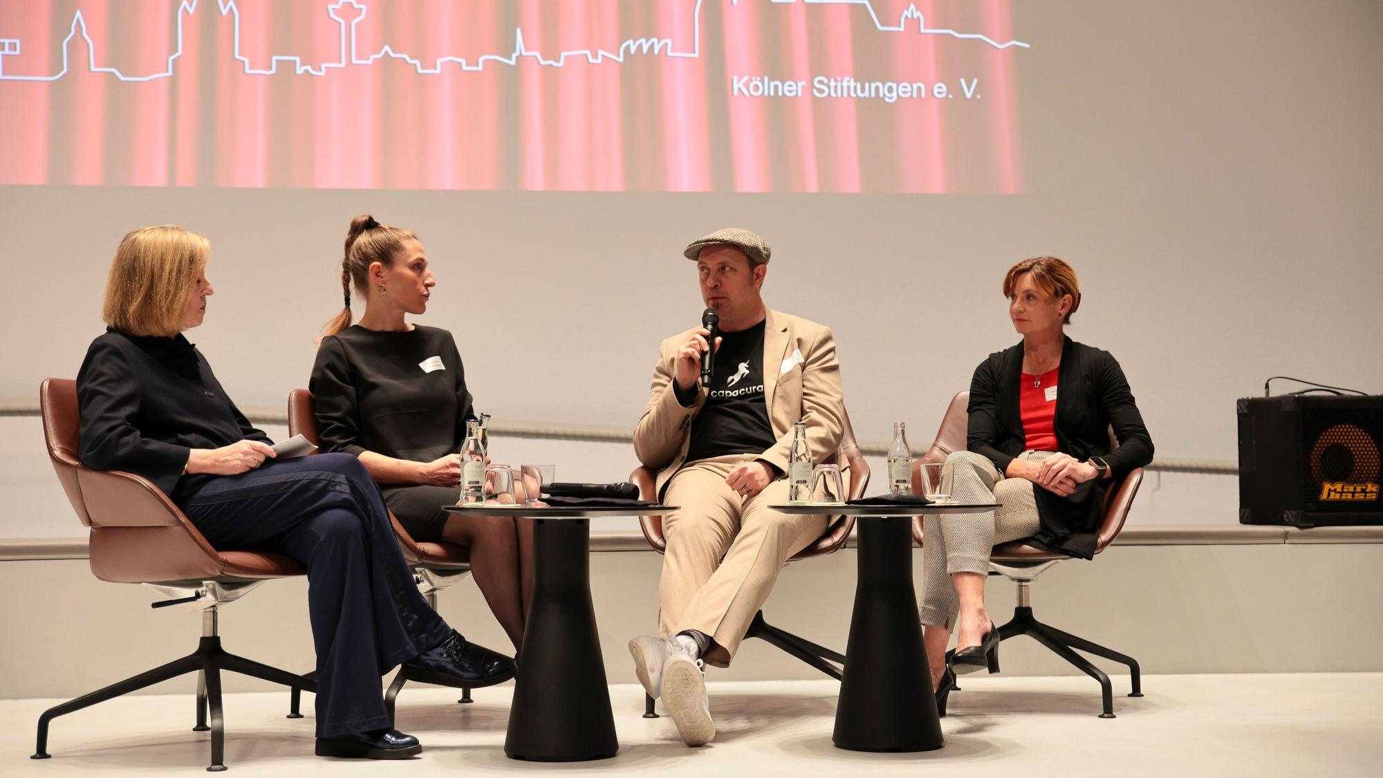Das Foto zeigt vier Personen bei einer Podiumsdiskussion.
