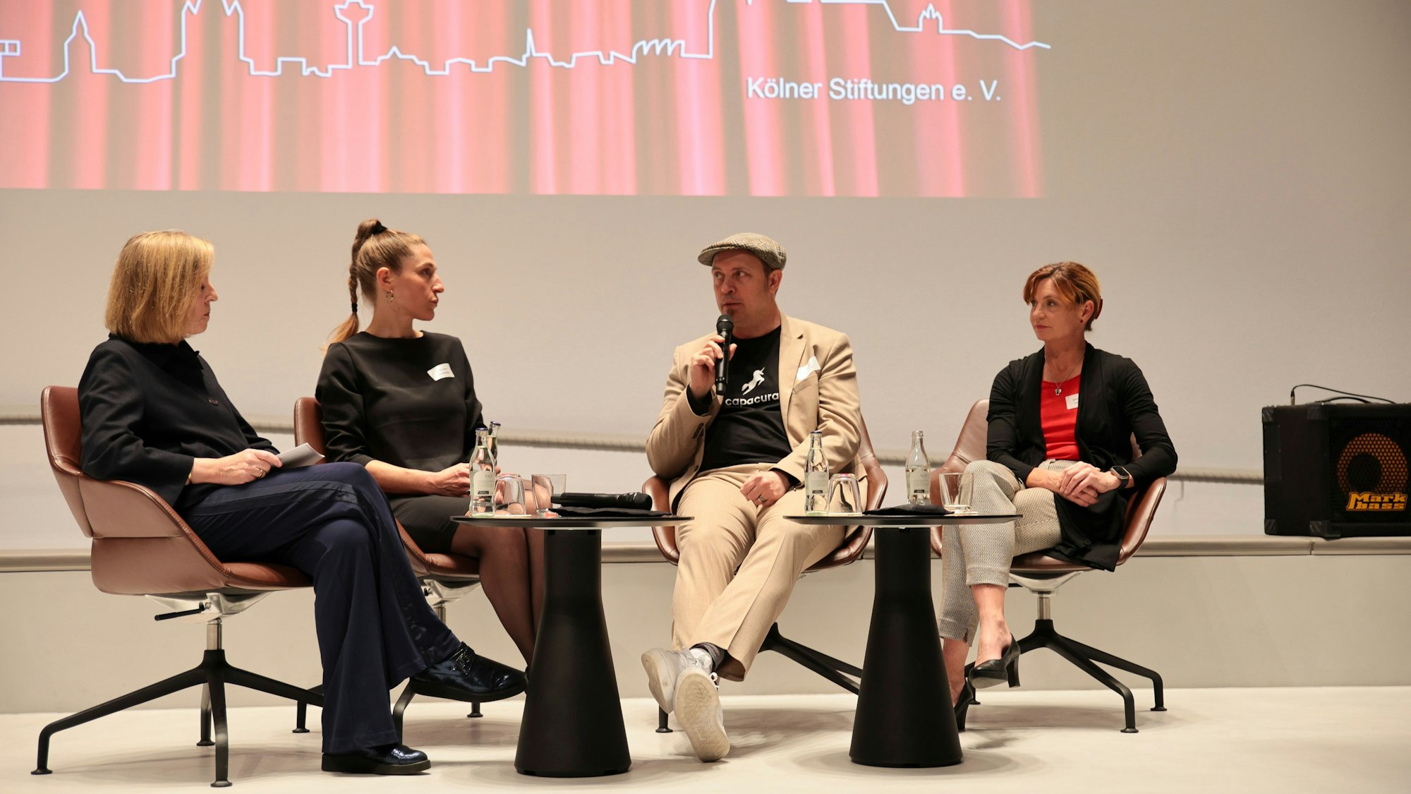 Das Foto zeigt vier Personen bei einer Podiumsdiskussion.