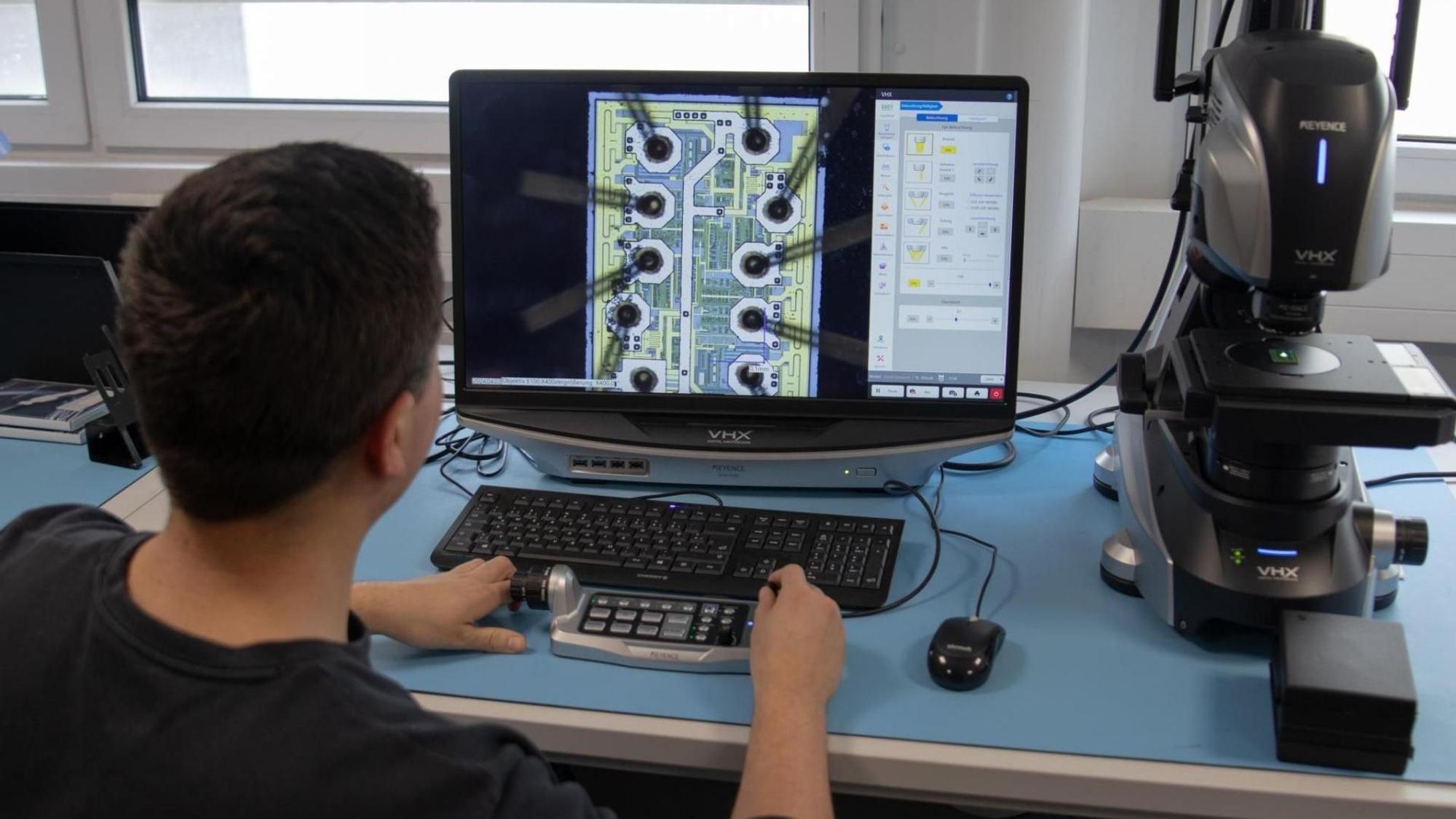 Ein Mann sitzt an einem Computer, auf dem Monitor ist eine Grafik zu sehen.