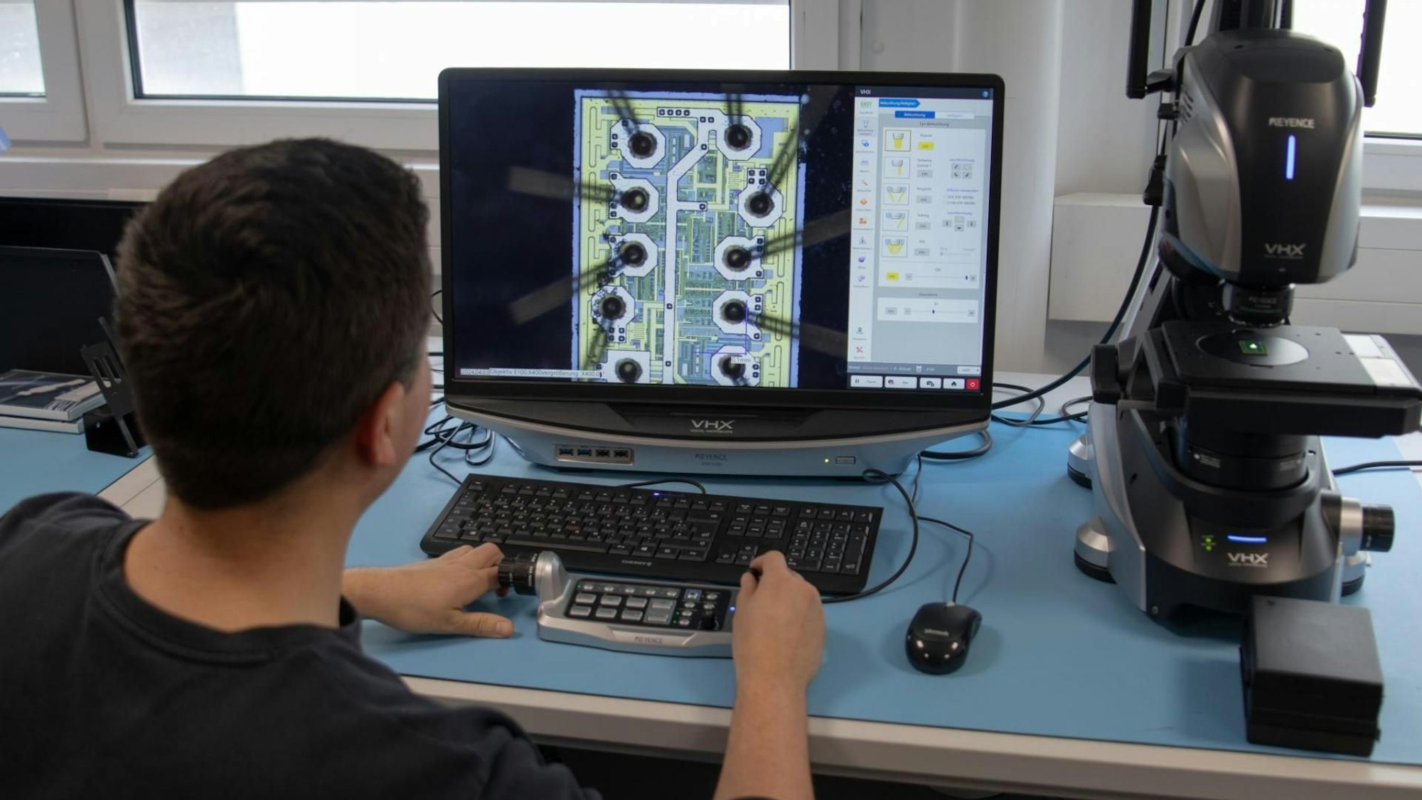 Ein Mann sitzt an einem Computer, auf dem Monitor ist eine Grafik zu sehen.