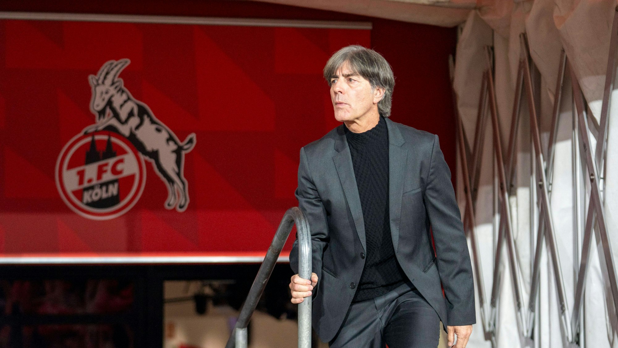 Joachim Löw kommt aus den Katakomben des Rhein-Energie-Stadions. Im Hintergrund ist das Logo des 1. FC Köln zu sehen.