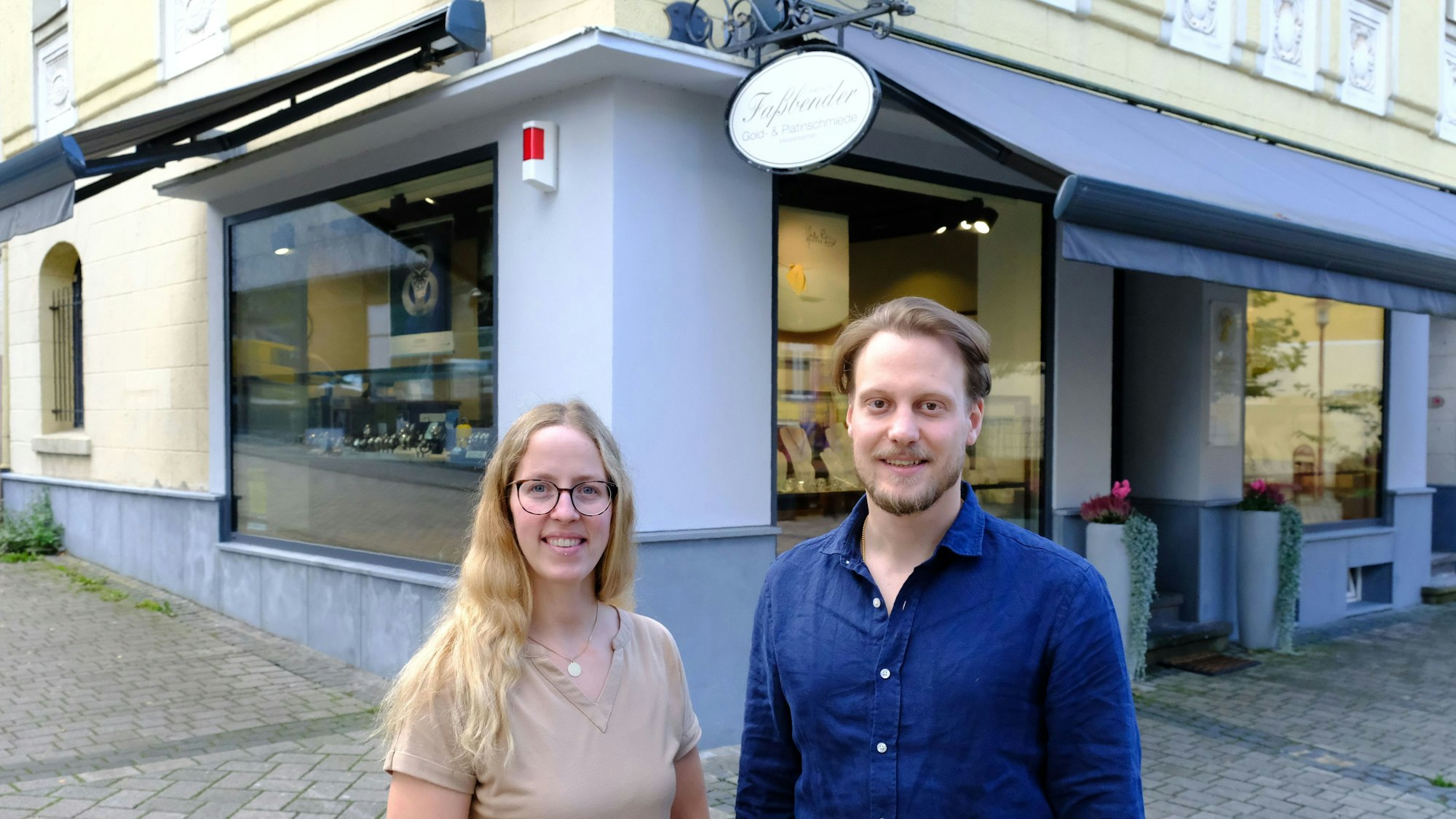 Aaron R. Faßbender und Diana Henninger stehen vor dem Juweliergeschäft in Gemünd.